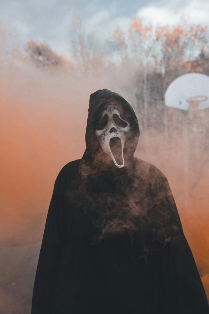 Ghostface - Photo de Erik Mclean: https://www.pexels.com/fr-fr/photo/silhouette-a-capuche-dans-le-brouillard-avec-masque-a-l-exterieur-29116303/